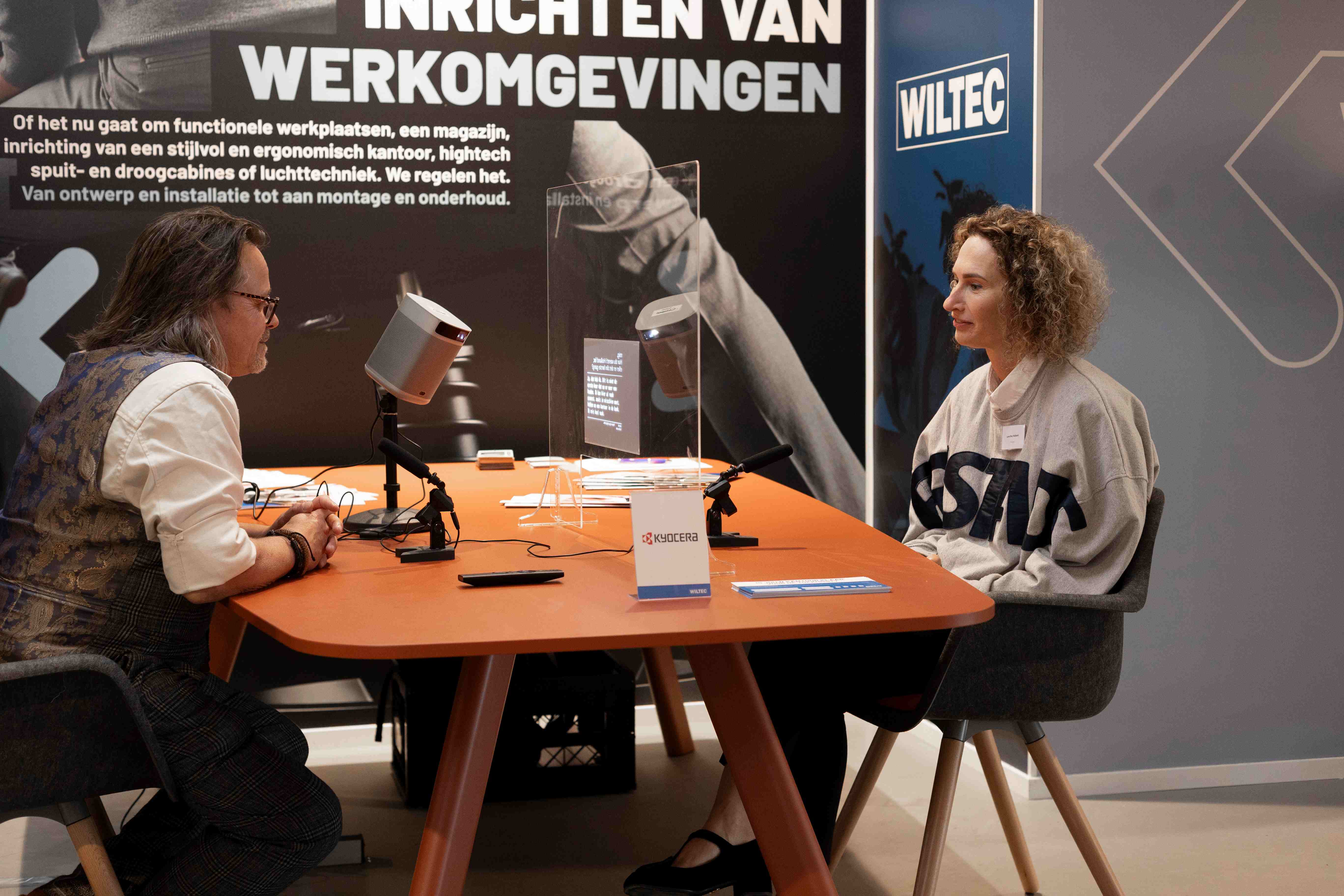 Cotopat live vertaling tijdens een gesprek met twee personen en een transparant scherm