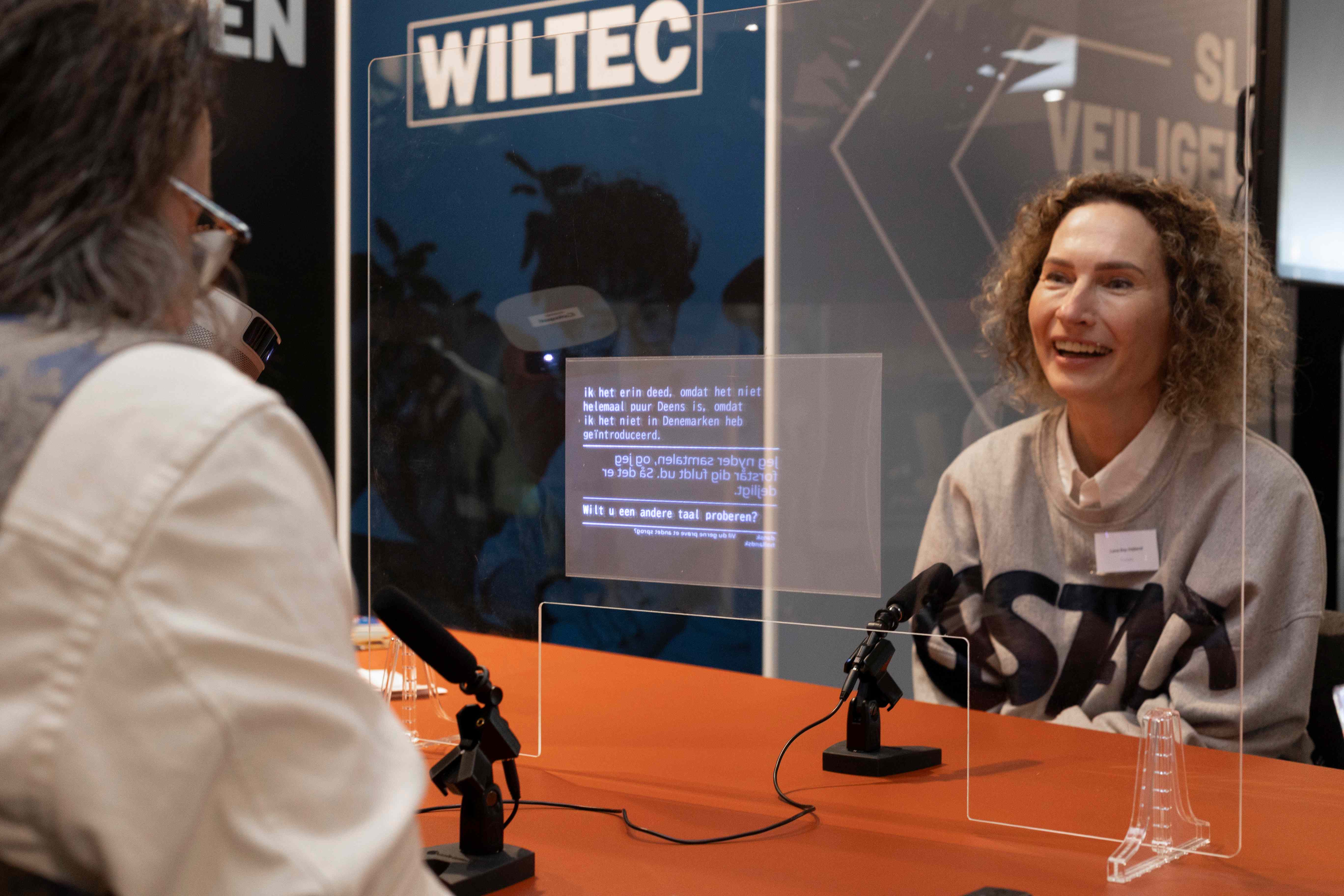Cotopat in gesprekssituatie met live vertaling op transparant scherm